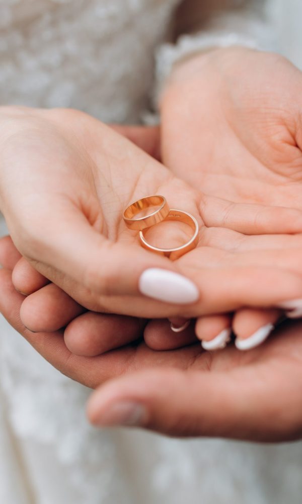 Groom holds bride's hands, where are two wedding rings